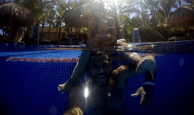 casal e bebê na piscina do hotel
