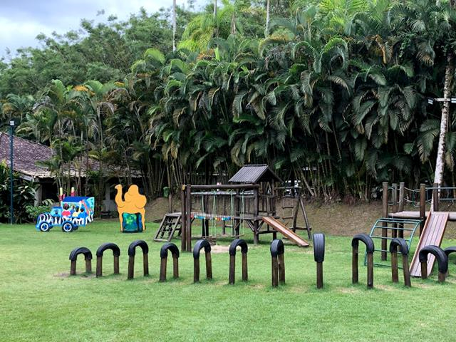 área externa com brinquedos de madeira, gramados, árvores, escorrega, miniclube do portobello