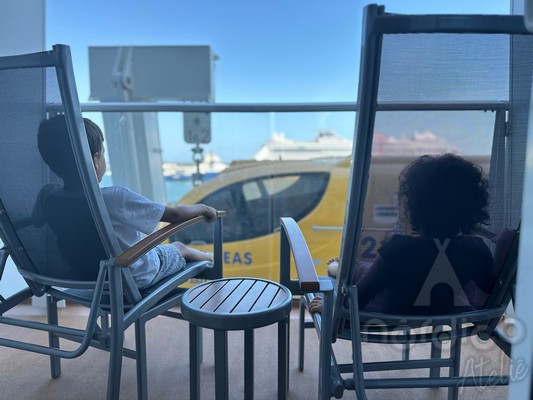 Foto da varanda da cabine 6270 do Odyssey Of The Seas, que tem a vista parcialmente obstruída pelo bote salva-vidas.