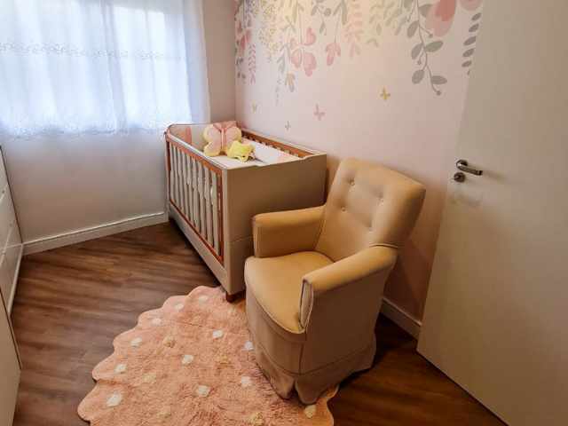 Tapete Infantil rosa em um quarto de bebê menina, localizado embaixo da poltrona de amamentação e próximo ao berço