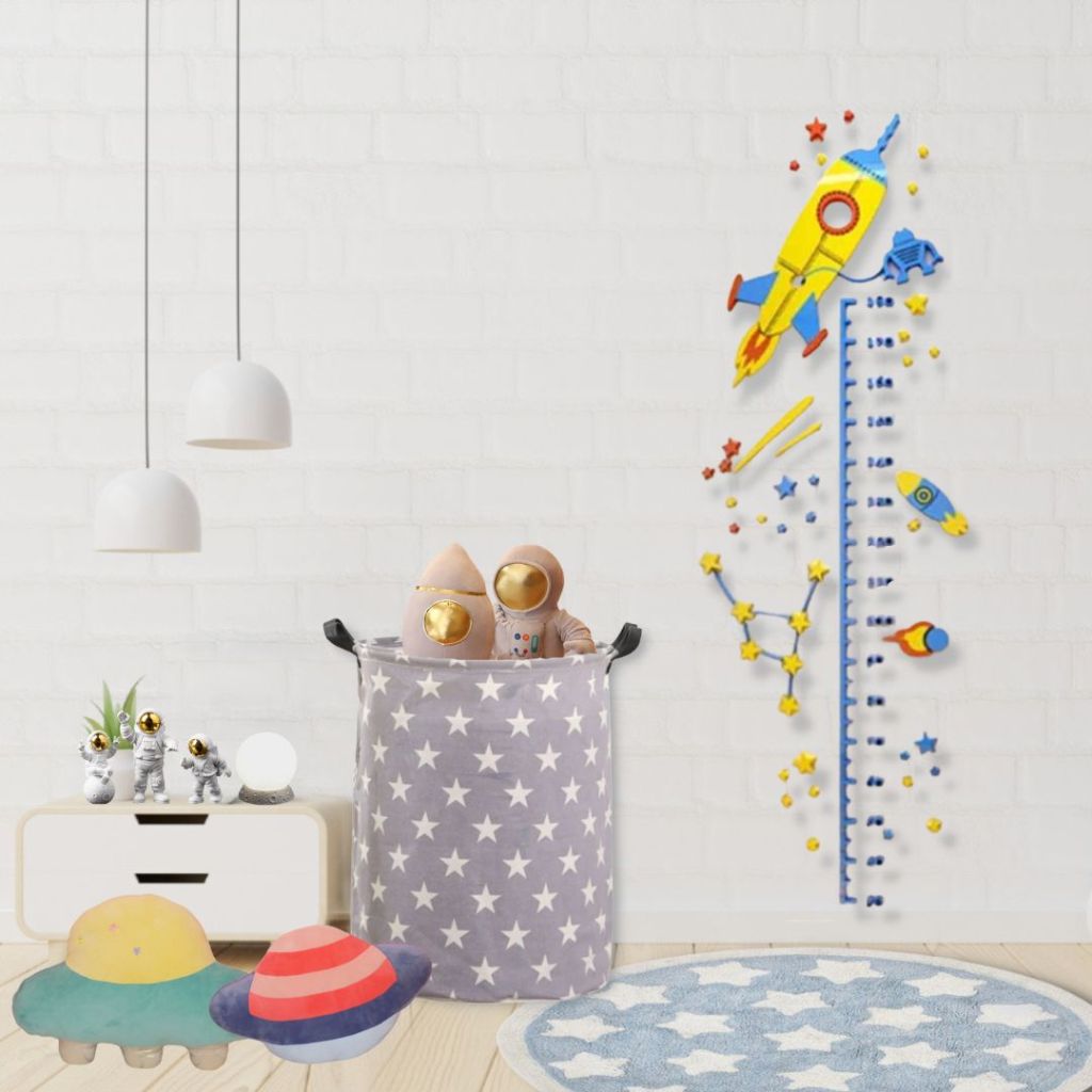 Quarto com decoração temática espacial com tapete, régua de crescimento, cesto, pelúcias e almofadas